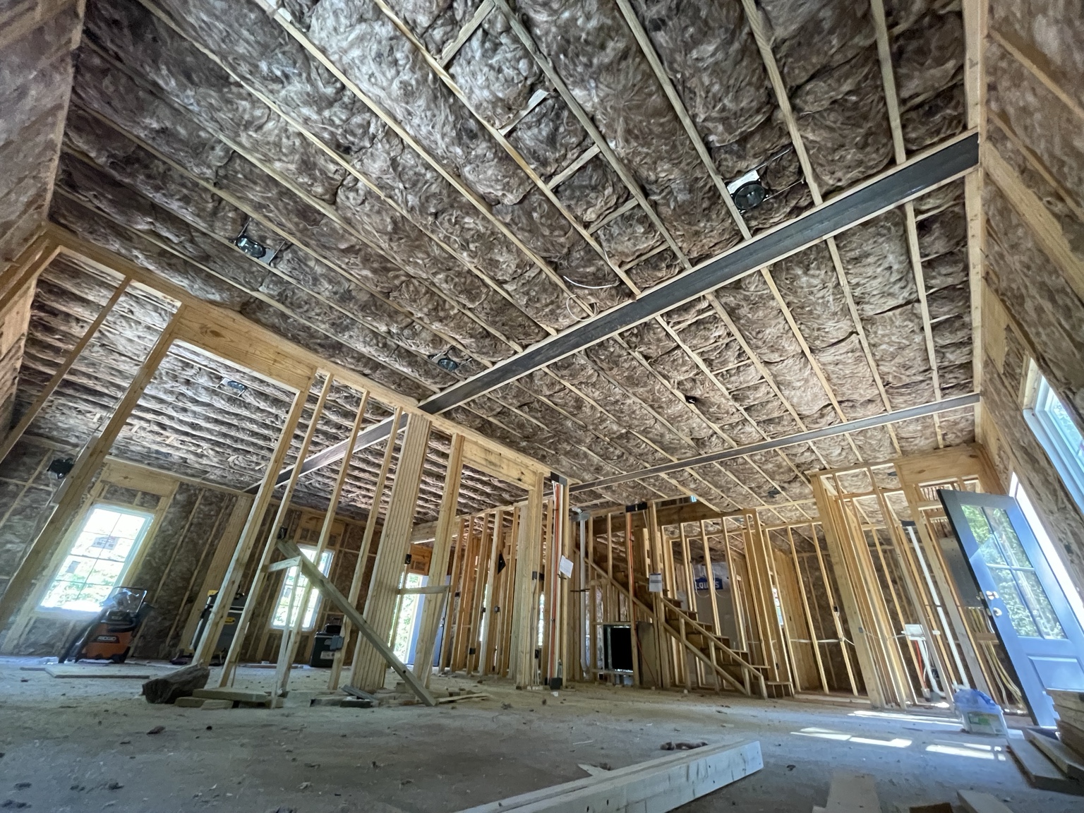 Large new construction interior with wall and ceiling batt insulation