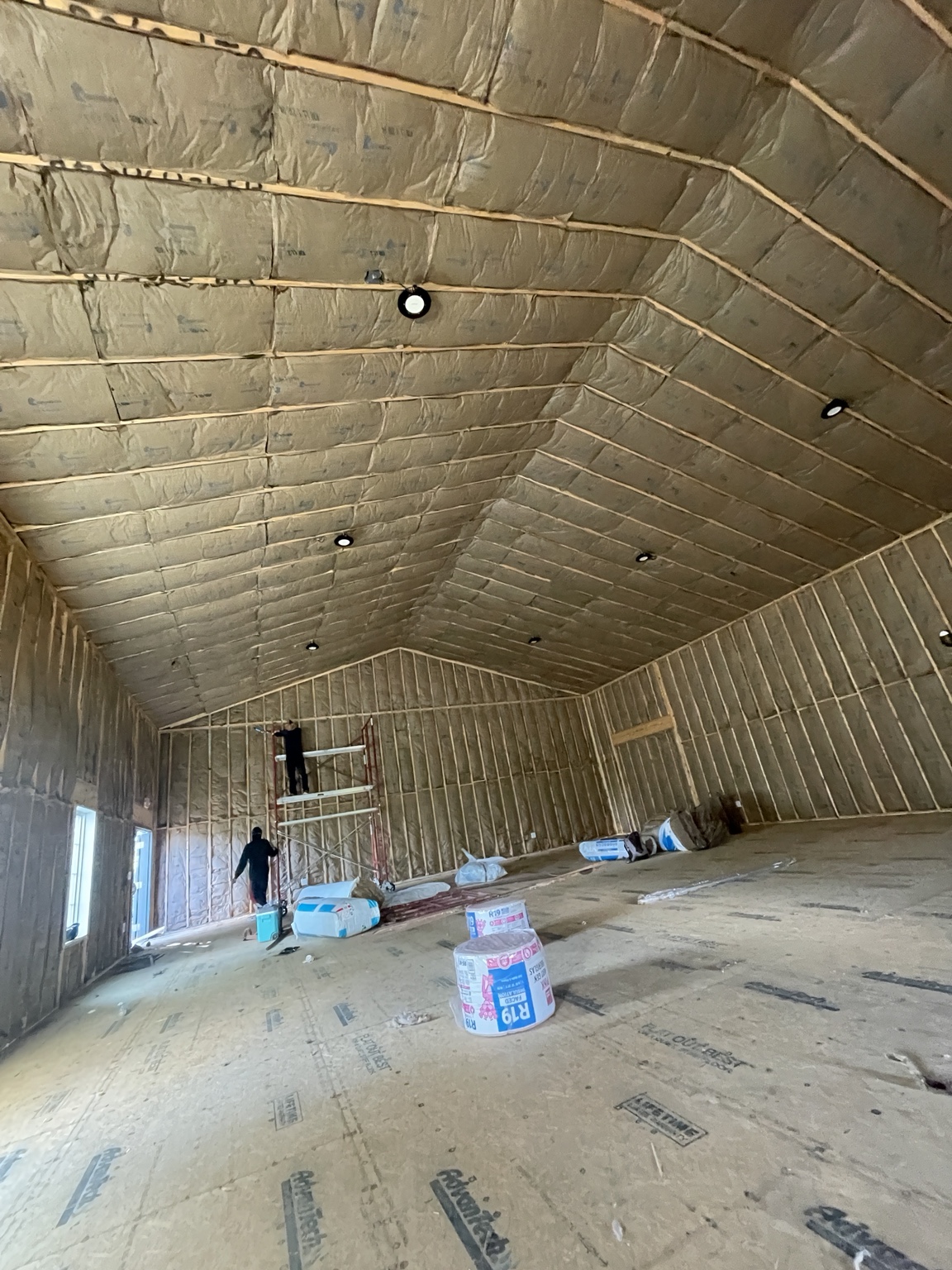 NRJ Insulation crew installing batts in a large vaulted building