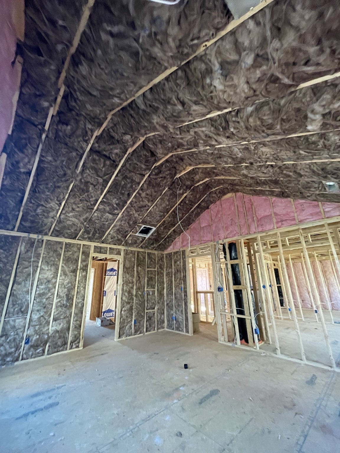 Fiberglass batt insulation installed in high walls and a vaulted ceiling